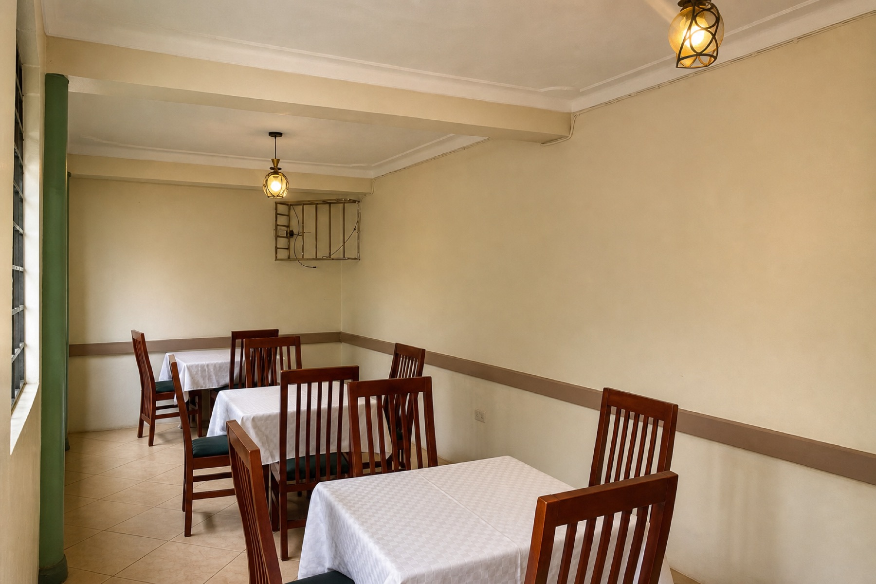 Tables laid with white cloths in the indoor dining room at Maganjo