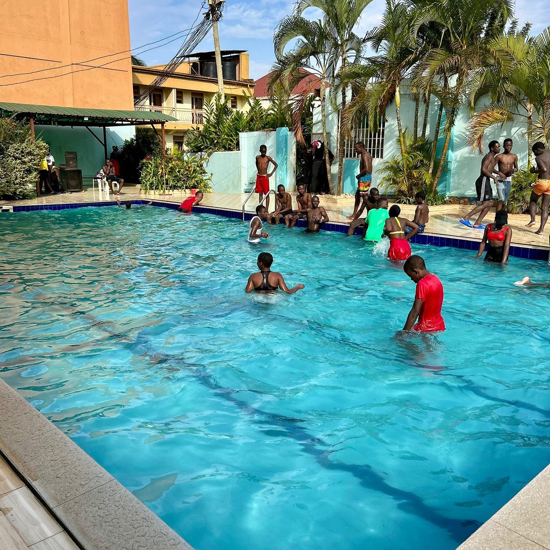 Children and families swimming in the main pool at Maganjo