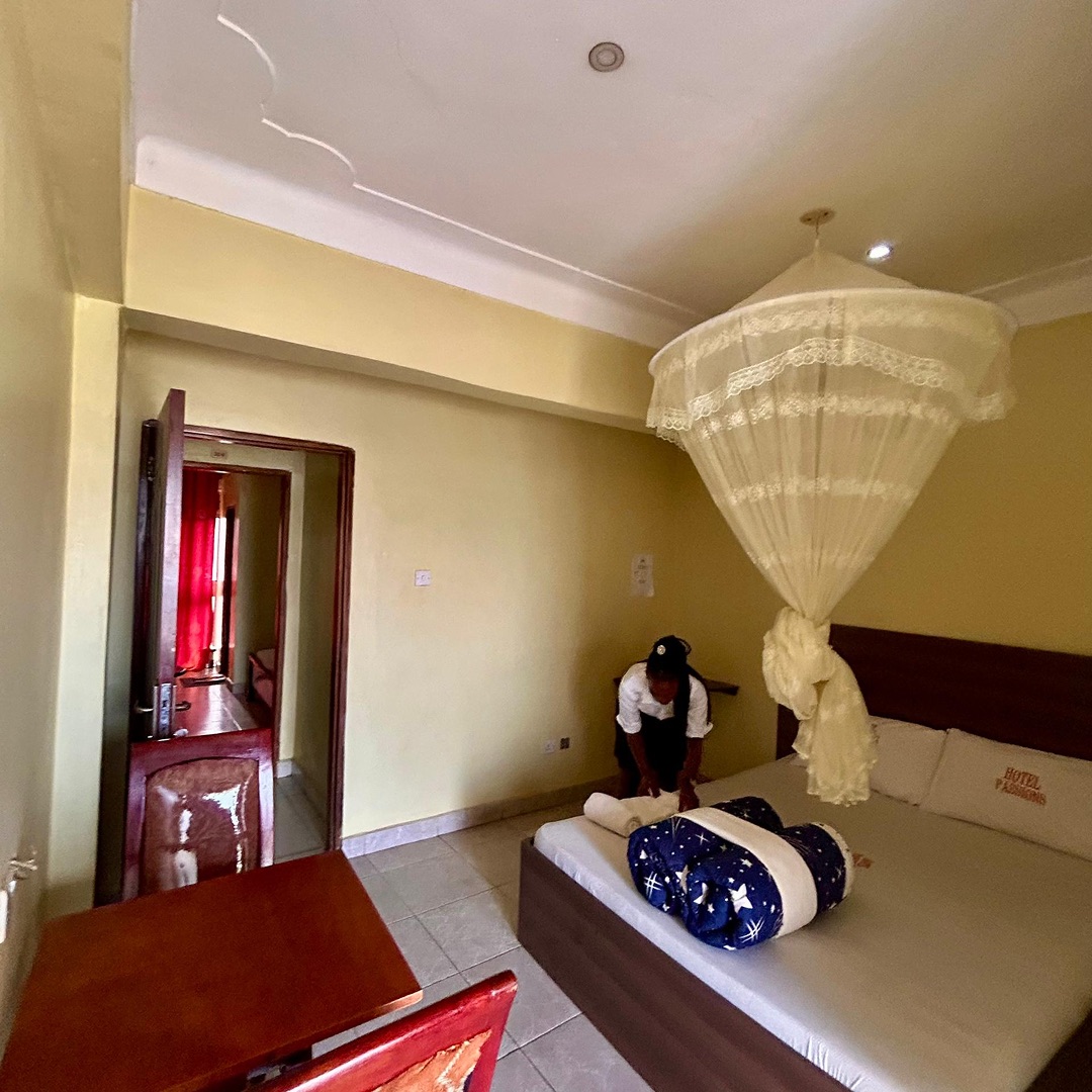 A guest room being made up, with a net over the bed